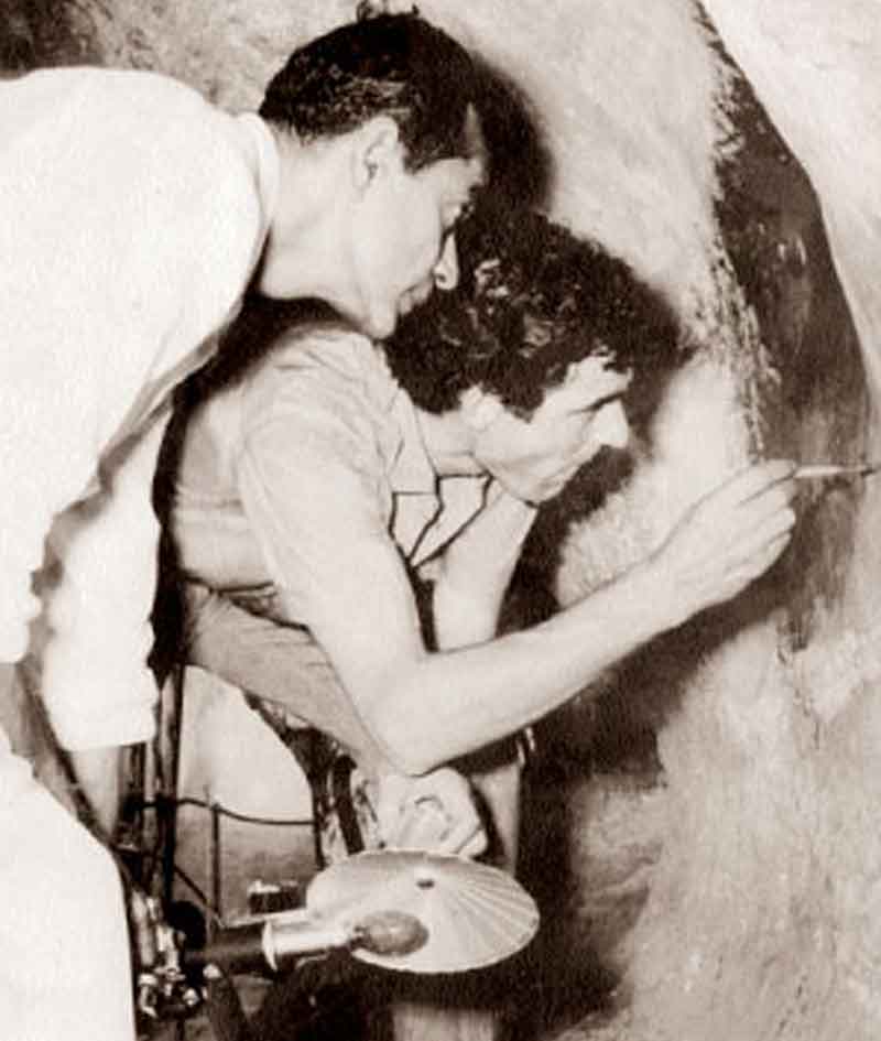 Raja de Silva and Luciano Maranzi cleaning the destroyed paintings by soaking a cotton swab.